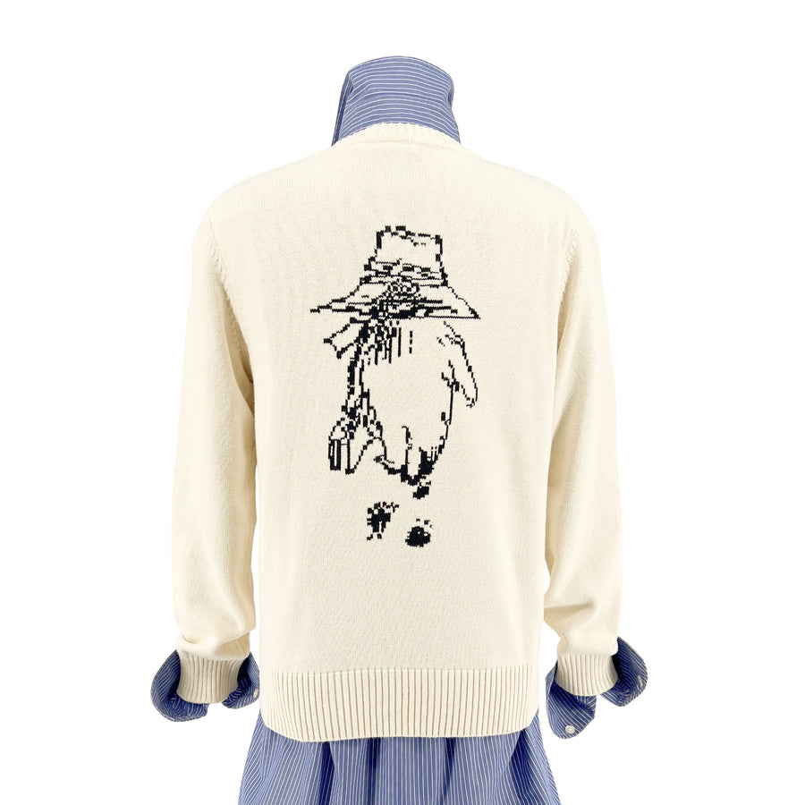 Ivory sweater with a Paddington Bear design in back, layered over a blue striped shirt