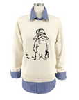 Ivory sweater with a Paddington Bear design in front, layered over a blue striped shirt