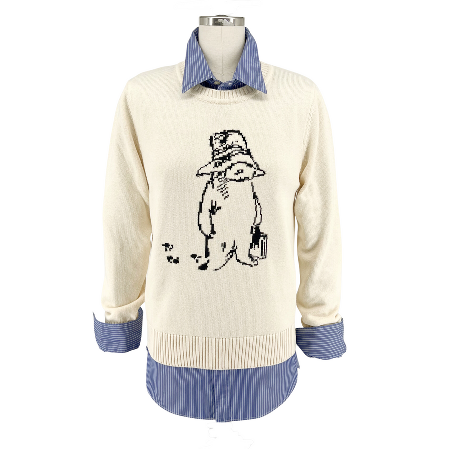 Ivory sweater with a Paddington Bear design in front, layered over a blue striped shirt