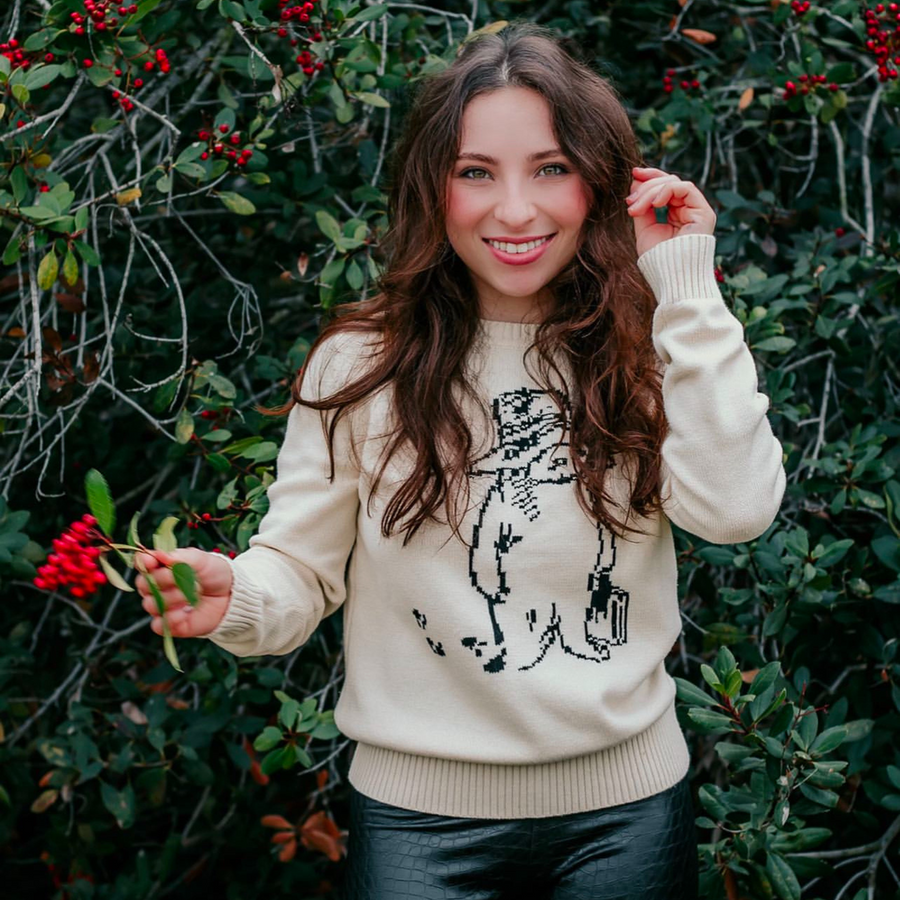 woman wearing an ivory sweater with a Paddington bear design