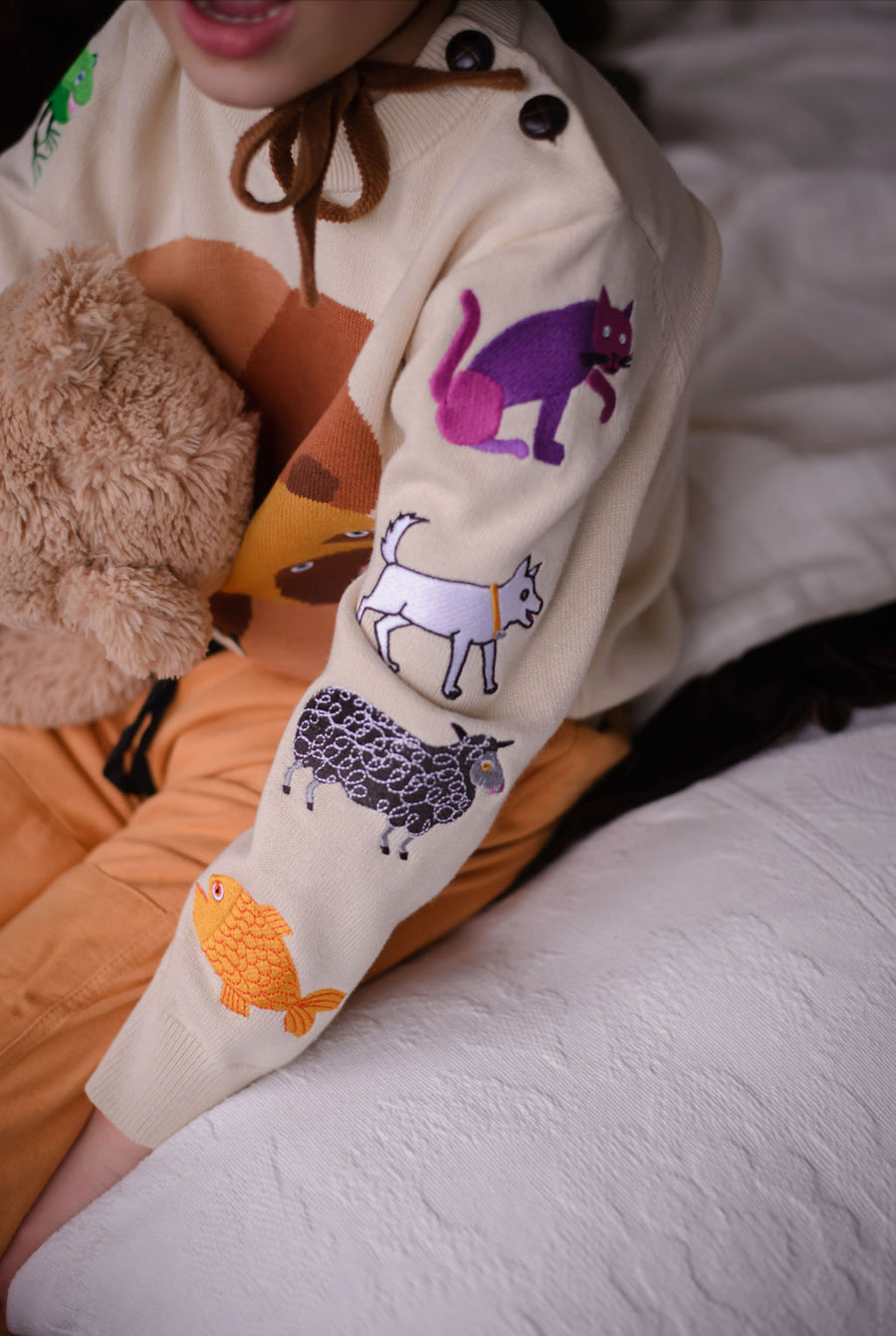 Close-up of a child's right sleeve featuring colorful embroidered animals