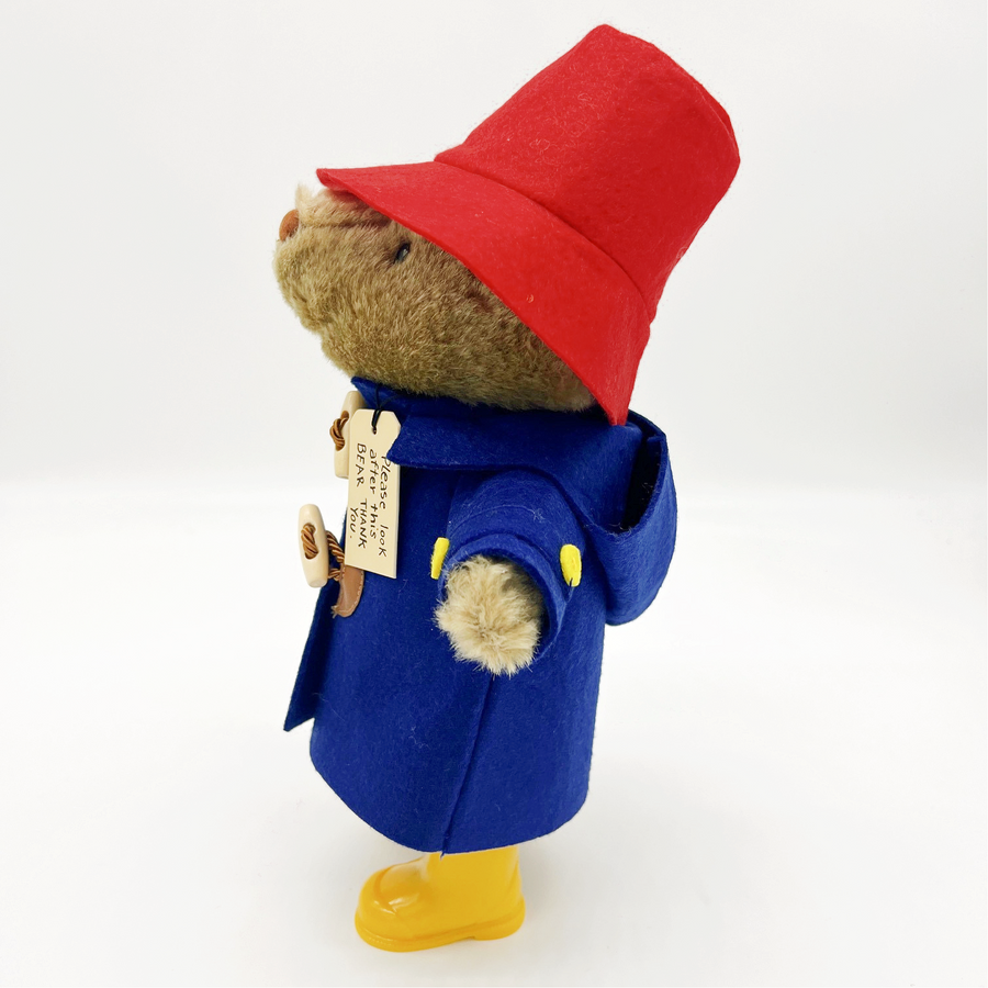 Paddington soft toy, 10 inches tall, side view, wearing a red hat, blue coat, and yellow boots.