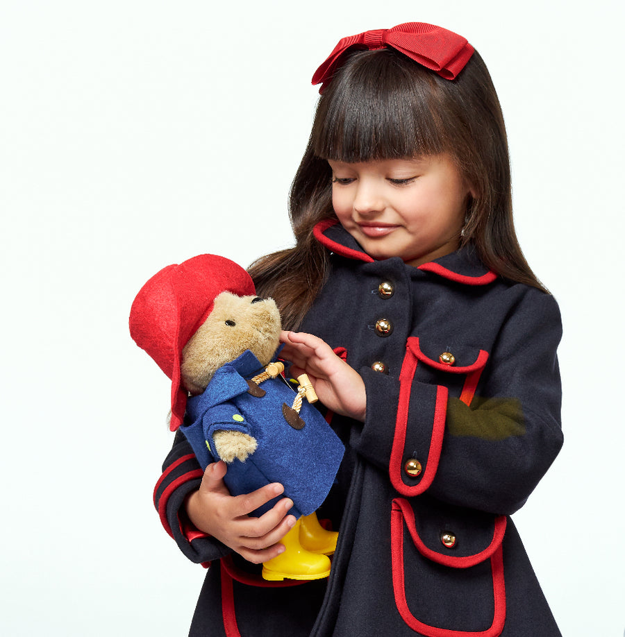 little girl Paddington's classic navy and red  dress coat and soft toy