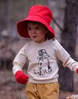 Child in Paddington sweater, red hat, and gloves