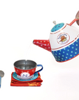 Hand pouring from Paddington-themed teapot into cup.