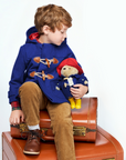 Boy in blue duffle coat with Paddington Bear plush