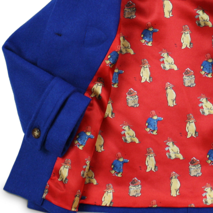 Lining of Paddington Blue duffle coat with toggles with red print of Paddington Bear