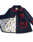 Navy blue coat with red trim, gold buttons, and a Paddington print lining