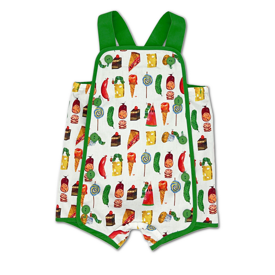 Colorful baby romper with a food-themed print, green straps, and button details