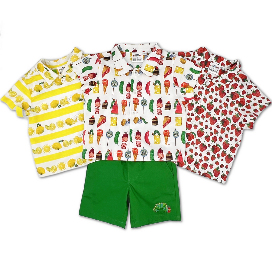 Three short-sleeve button-up shirts with vibrant fruit and food prints (lemons, mixed treats, and strawberries), paired with green shorts featuring a "Very Hungry Caterpillar" embroidery