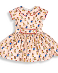 Pink vintage-style dress with Paddington Bear print, red piping, and a matching belt