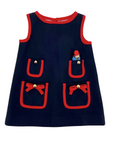 Navy blue girls' pocket dress with red trim, bow details, and a mini plush Paddington Bear