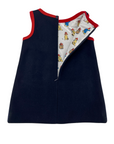 Back view of a girls' wool dress with red trim, with back zipper opened to reveal a satin lining with a Paddington bear fabric print.