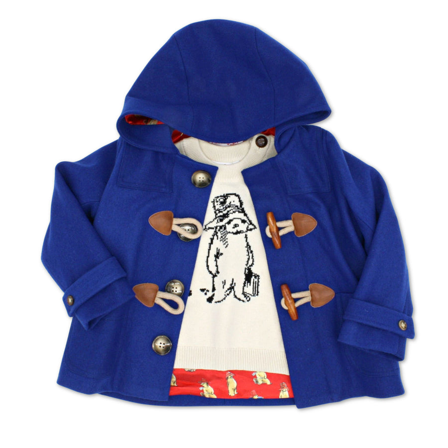 blue duffle coat over a Paddington bear sweater