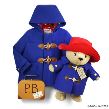 Blue Paddington duffle coat with a matching plush bear in a red hat and suitcase