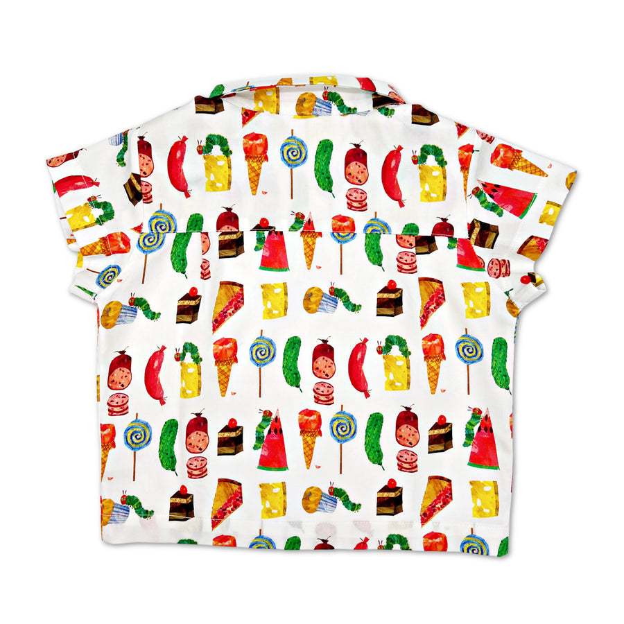 Back view of a children's short-sleeve button-up shirt with a colorful print featuring various foods, such as cheese, ice cream, lollipops, watermelon, and cake, along with the green caterpillar from The Very Hungry Caterpillar by Eric Carle